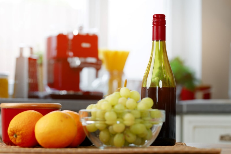 Bouteille de vin à côté de fruits dans la cuisine