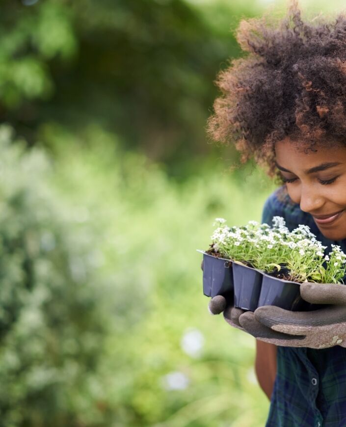 Jeune femme sentant des amorces de fleurs