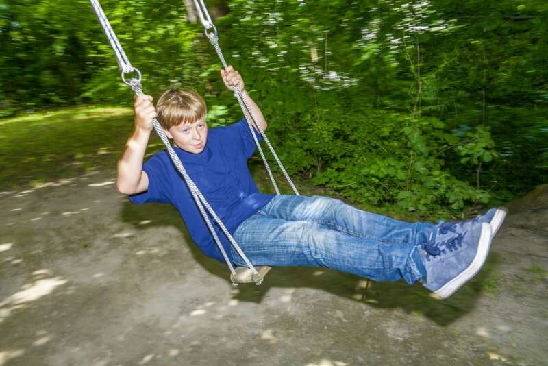 Un jeune garçon se balançant sur la meilleure option de balançoire dans un arbre