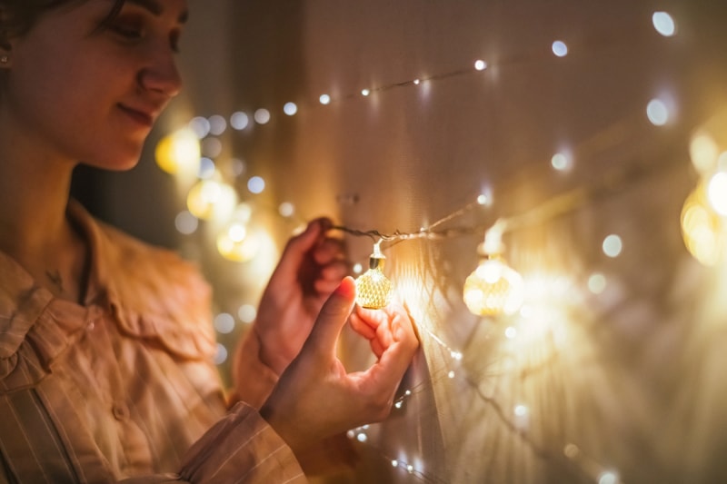 Femme remplaçant une ampoule de Noël.