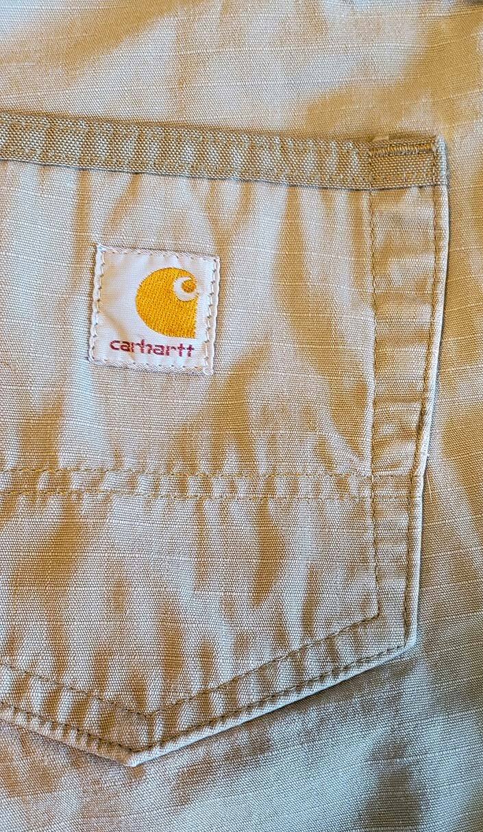 Gros plan de la poche arrière du pantalon cargo Carhartt avec logo