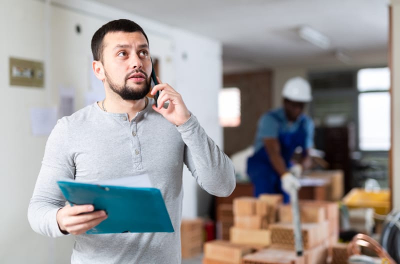 entrepreneur parlant au téléphone sur un chantier de construction