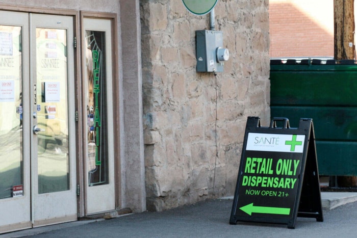 devanture de magasin avec enseigne extérieure annonçant un dispensaire de marijuana