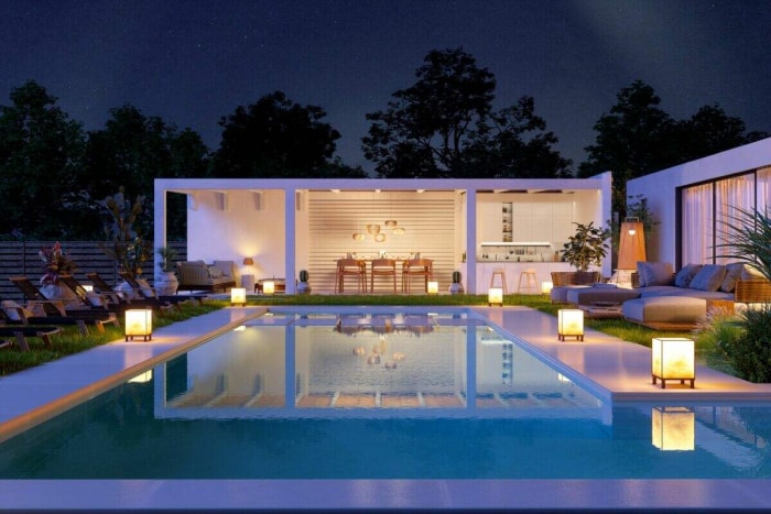 Une maison moderne avec une piscine éclairée par des lanternes sur la terrasse de la piscine. 