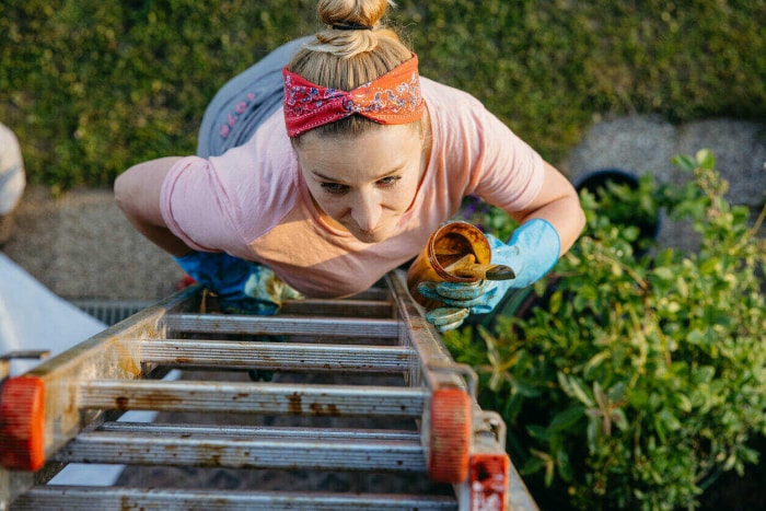 iStock-1359667480 productivité hacks femme grimpant sur une échelle pour peindre