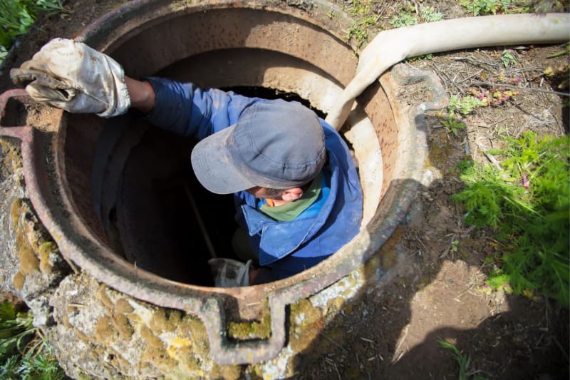 Un ouvrier descend dans un grand drain.