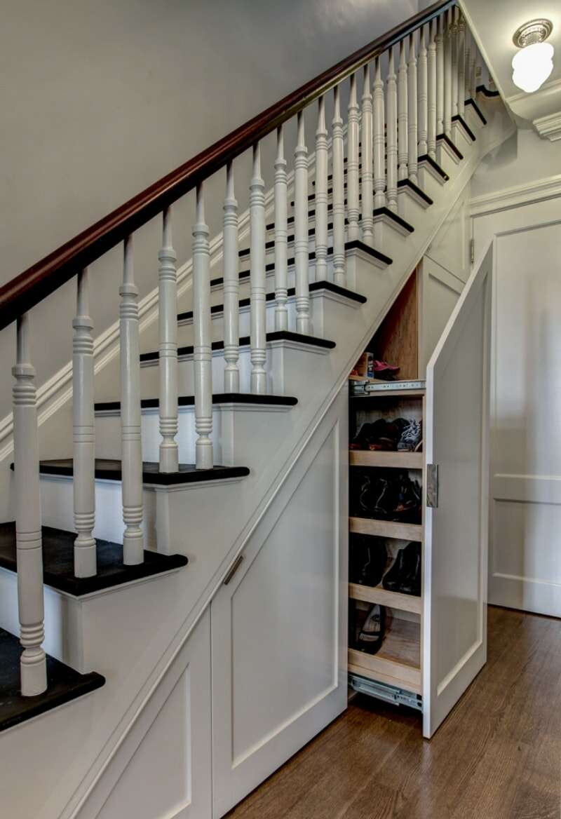 grand escalier blanc dans le hall d'entrée avec un grand tiroir à étages ouvert en dessous