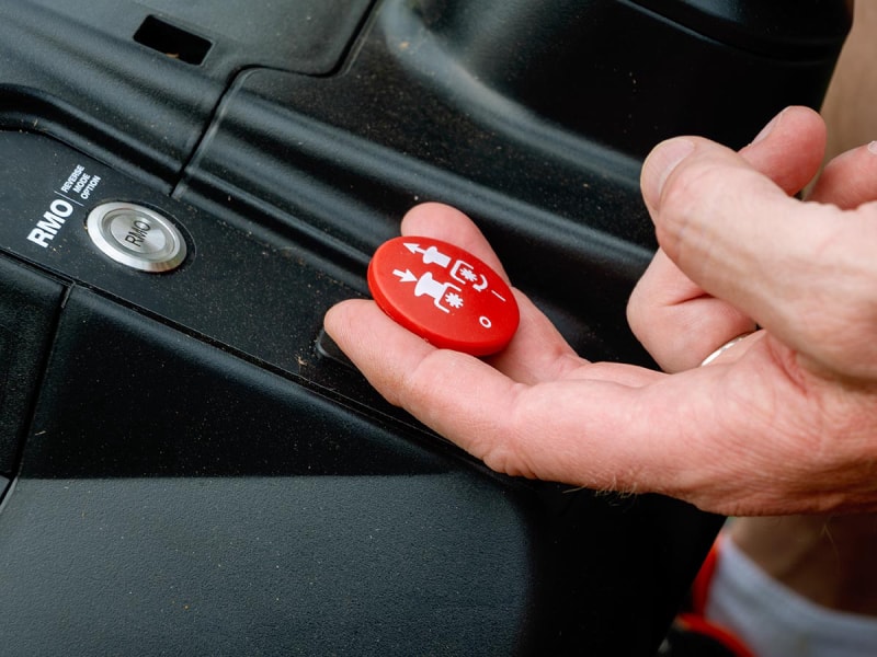 Lever à la main le bouton rouge d'engagement de la lame sur un tracteur de pelouse Ryobi