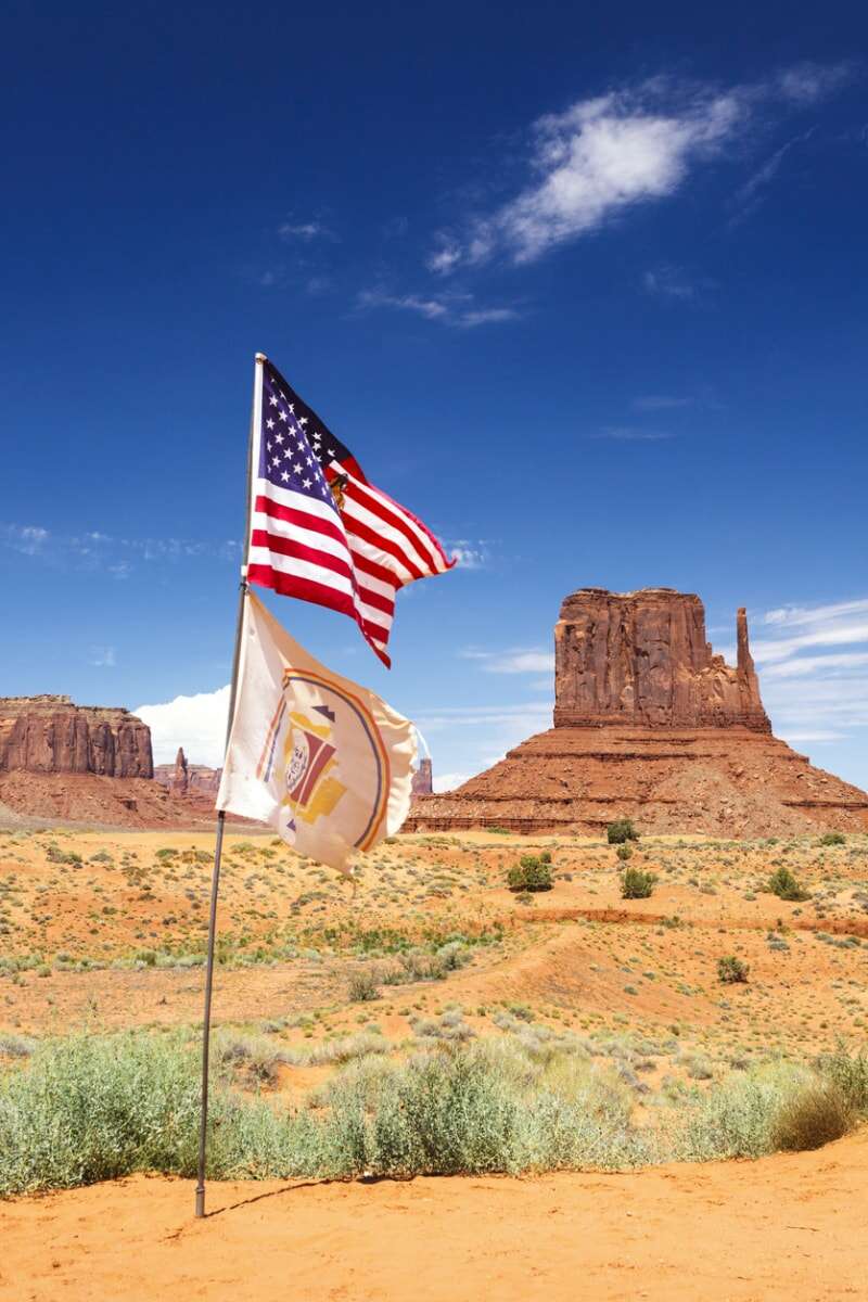 Drapeau américain et drapeau de la nation navajo. West Mitten Butte en arrière-plan, Monument Valley Navajo Tribal Park, Arizona, États-Unis.