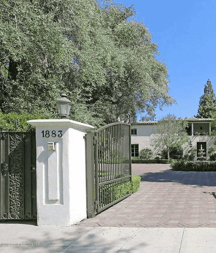 Une maison de style espagnol se trouve derrière une entrée fermée.