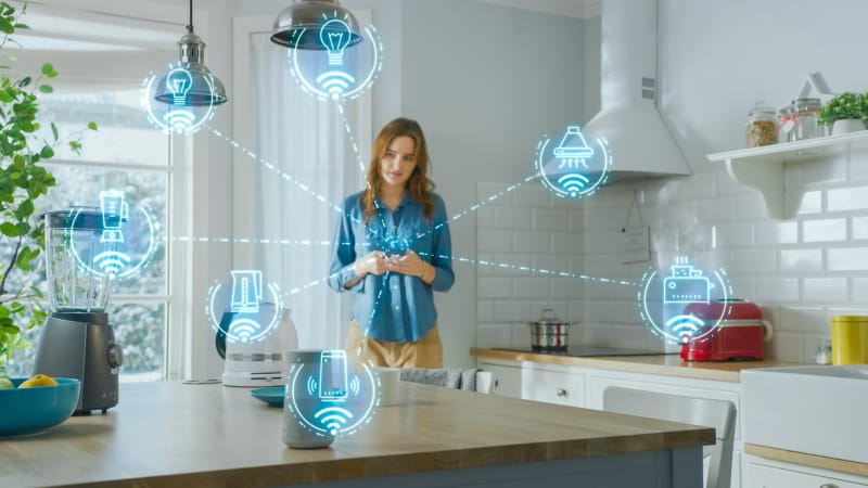 Les 11 plus grosses erreurs que vous pouvez commettre avec votre maison intelligente femme dans la cuisine entourée d'appareils de maison intelligente