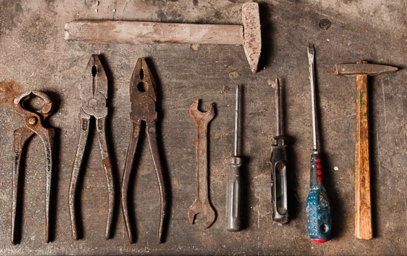 Vue aérienne d'outils rouillés sur un établi en bois.