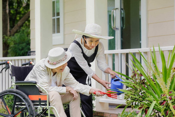 Une femme âgée jardine dans son jardin avec sa fille