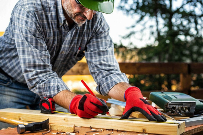 iStock-1184237494 opportunités de bénévolat homme construisant une clôture en bois à l'extérieur