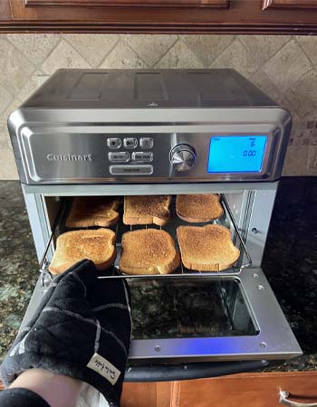 Personne retirant des toasts du grille-pain-four Cuisinart air fryer