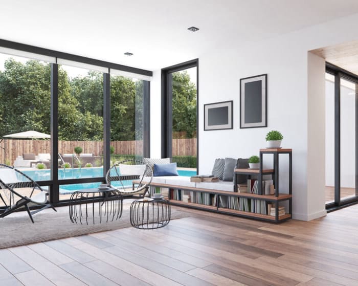 Portes coulissantes en verre sur une maison de style moderne avec une piscine visible à l'extérieur et du parquet à l'intérieur.