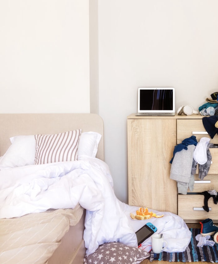 une femme est entrée dans la chambre de son enfant avec un désordre pour ramasser des choses sales et nettoyer