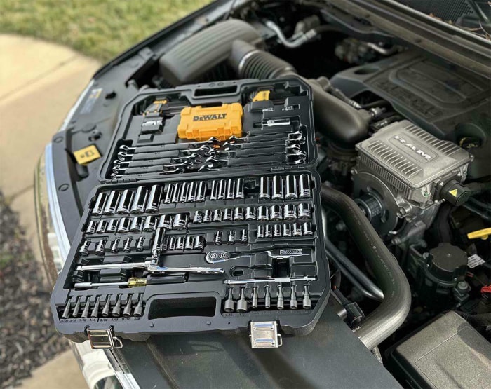 L'ensemble d'outils mécaniques DeWalt ouvert sur le dessus d'un moteur de voiture