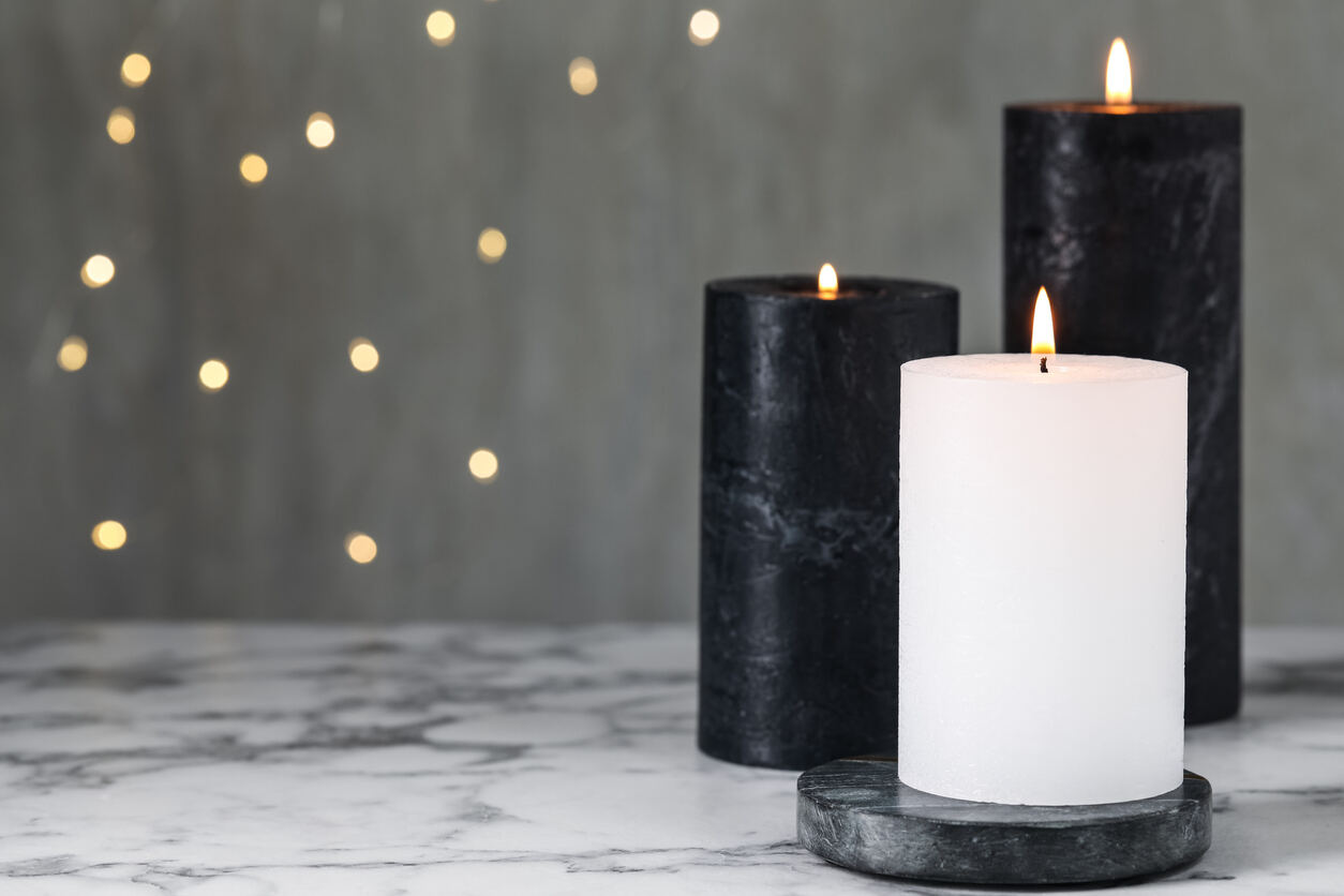 Bougies allumées sur une table en vinyle blanc sur fond de lumières floues