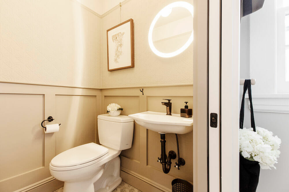 Une demi-salle de bain chaleureuse et éclairée dans une vieille maison rénovée.