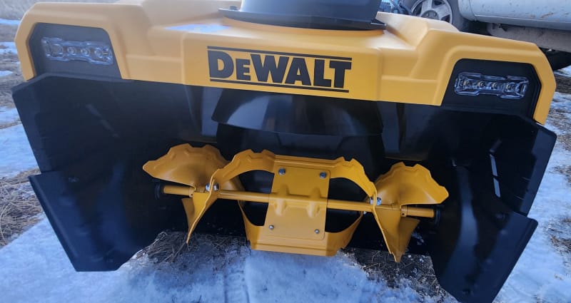 Fraise à neige Dewalt positionnée à l'extérieur sur une allée dégagée